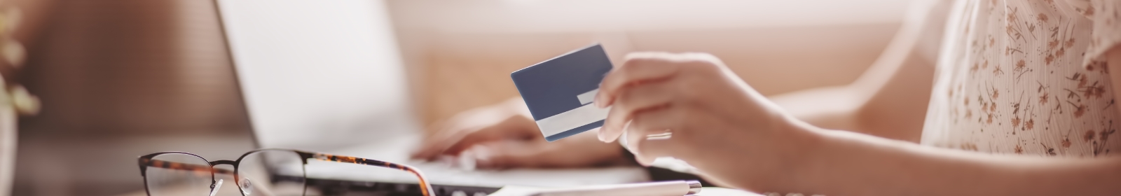 someone using a laptop with their debit card in hand